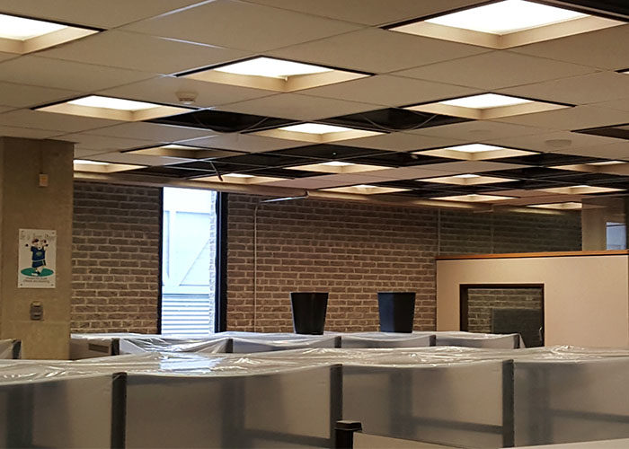 Study booths are covered with plastic, ceiling tiles are missing and pails are positioned to catch dripping water on the seventh floor of the Library building. (Mallory Warren)