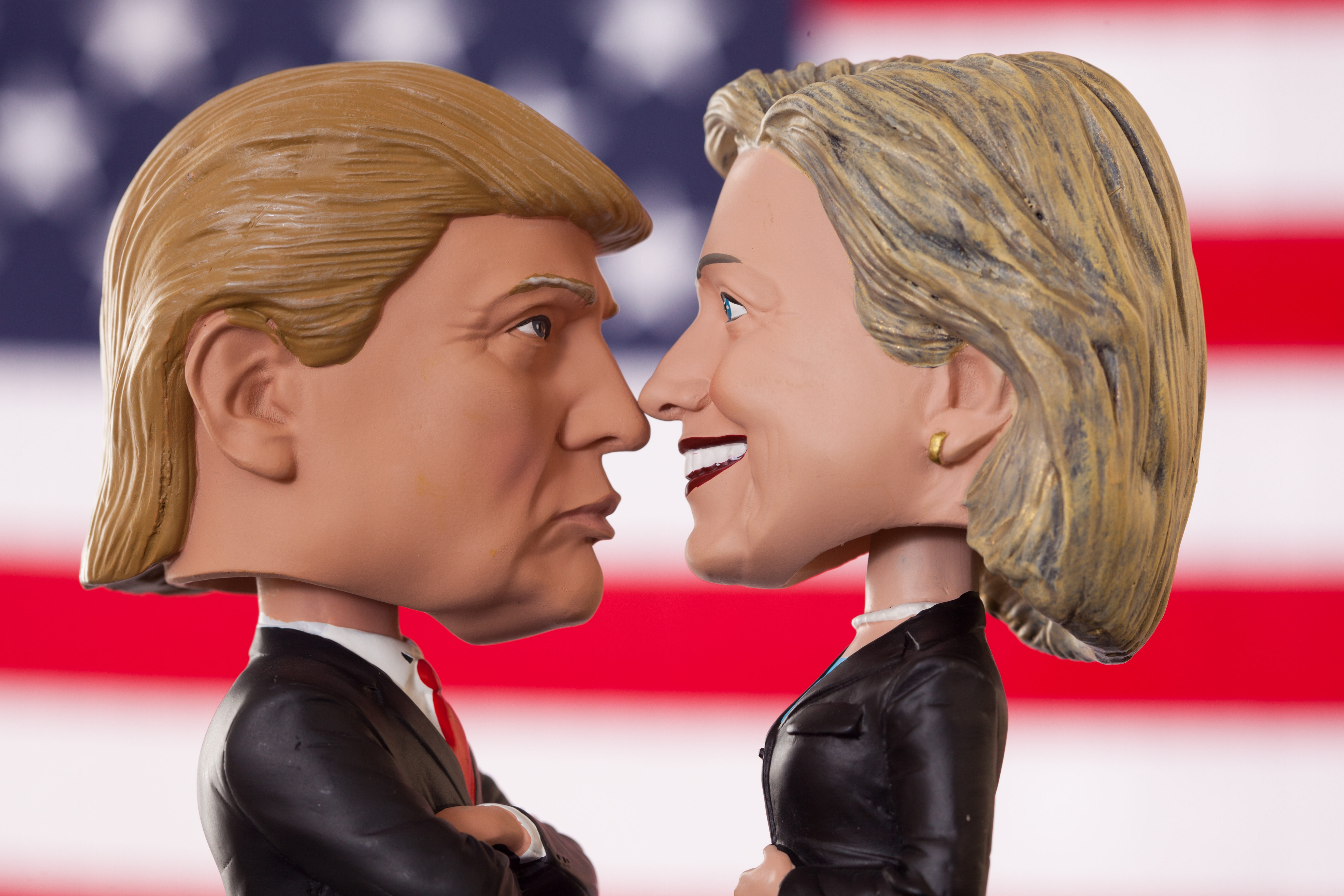 Lexington, KY, United States - October 5, 2016: Bobblehead dolls of 2016 presidential candidates Hillary Clinton and Donald Trump are pictured in front of an American flag. Donald Trump and Hillary Clinton faced off as Republican and Democratic candidates during their 2016 bid for the title of President of the United States. Produced by Royal Bobbles, these realistic figures have become popular preceding the November 8th election.