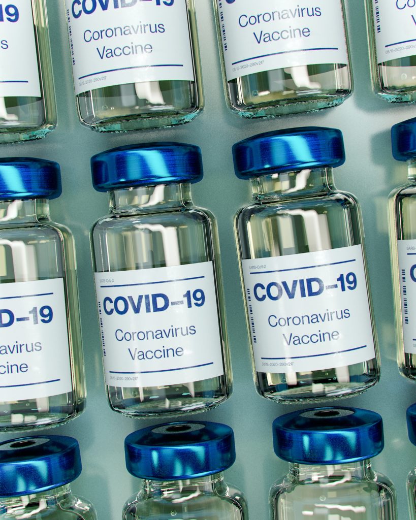 vials of the COVID-19 vaccine placed side-by-side on a desk