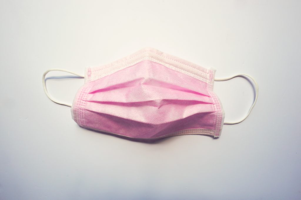 a surgical pink mask on a desk