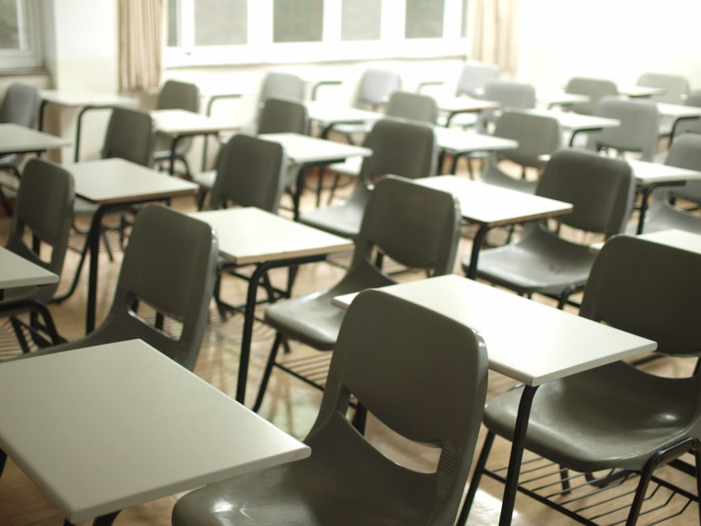 empty rows of desks and chairs in a school classroom