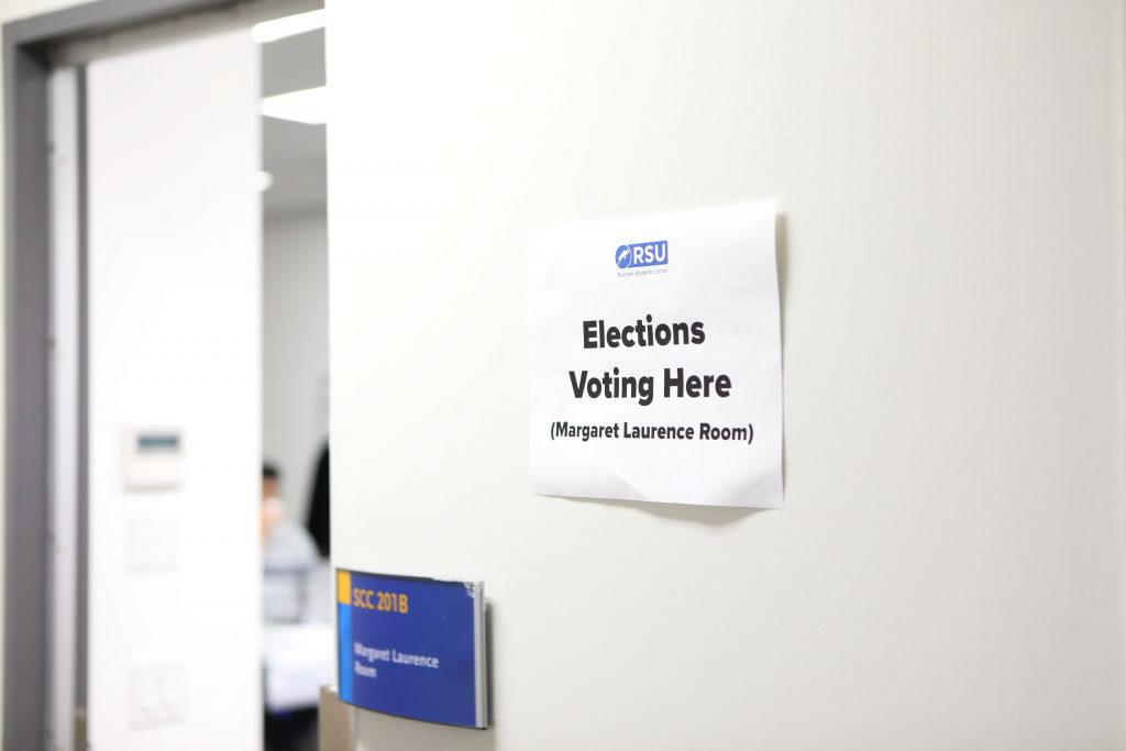 A sign on a door that says "Election voting here" with the RSU logo on it