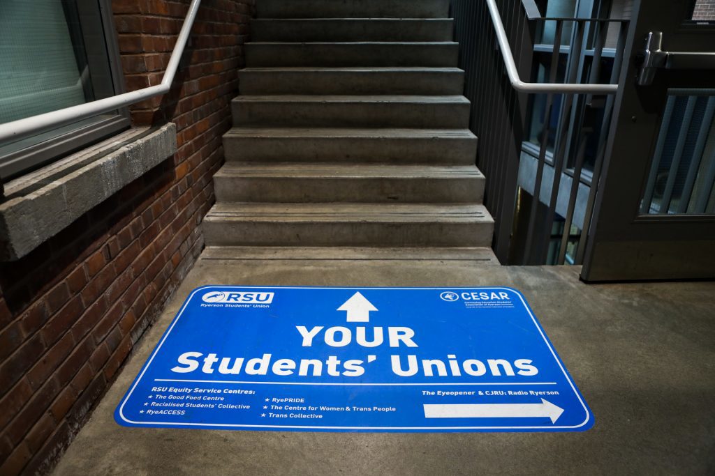 Sign on ground next to stairs providing directions to RSU services