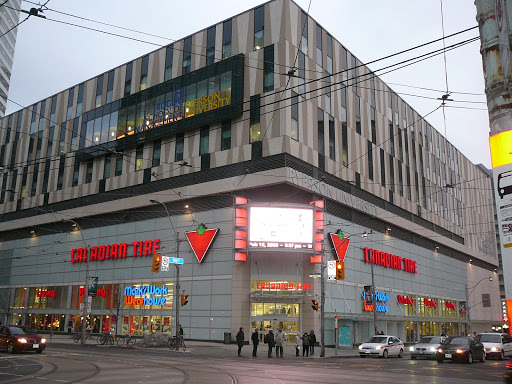 the corner of a Canadian Tire building on a rainy evening